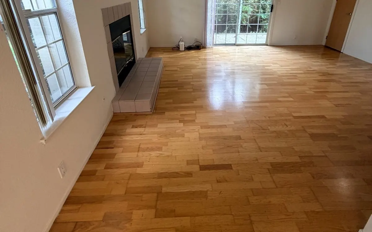 Empty living room with a freshly cleaned oak hardwood floor
