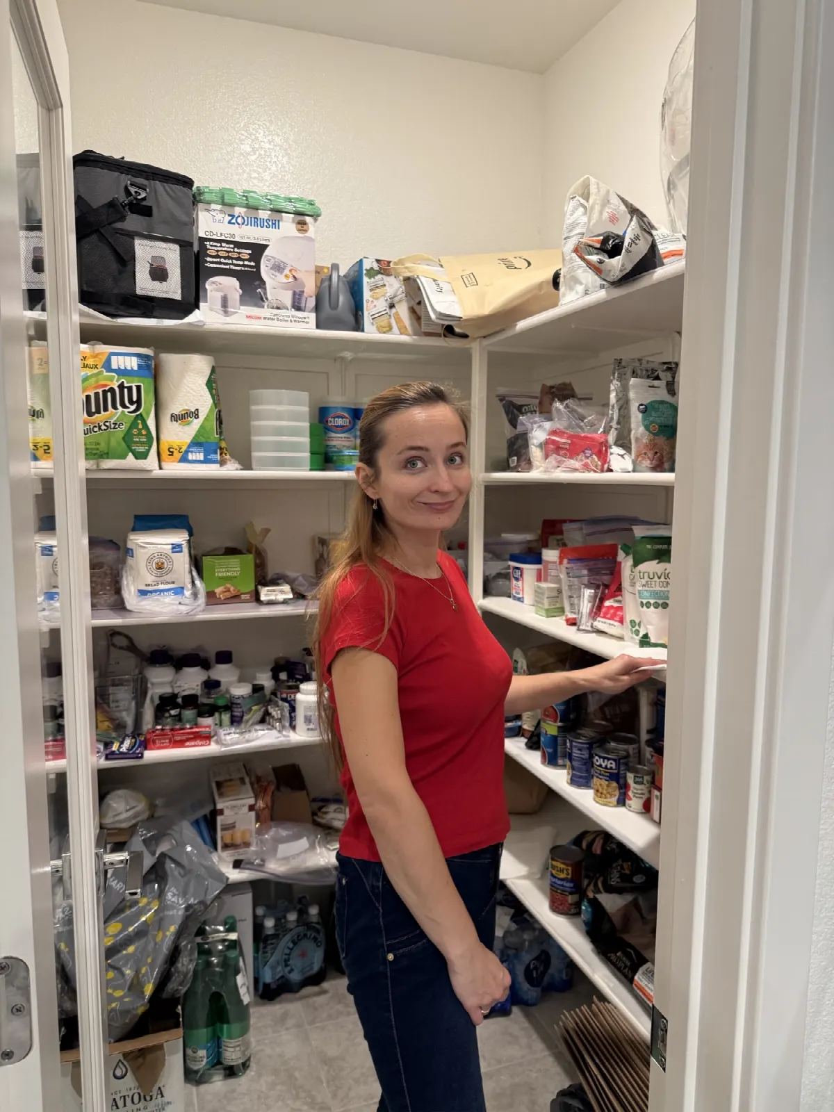 Crew member sorting labeled pantry shelves during a home organizing visit