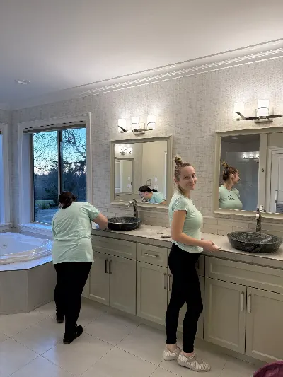 Two cleaners cleaning a primary bathroom vanity