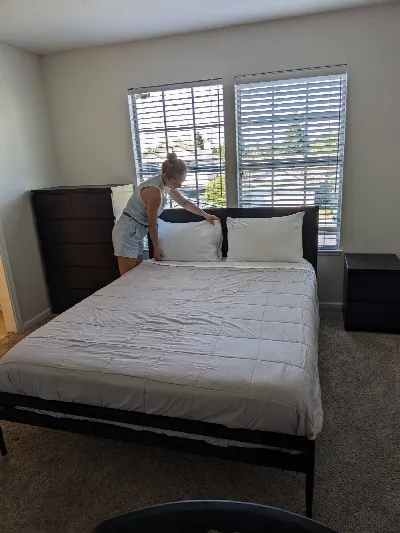 Cleaner straightening pillows on a freshly made bed
