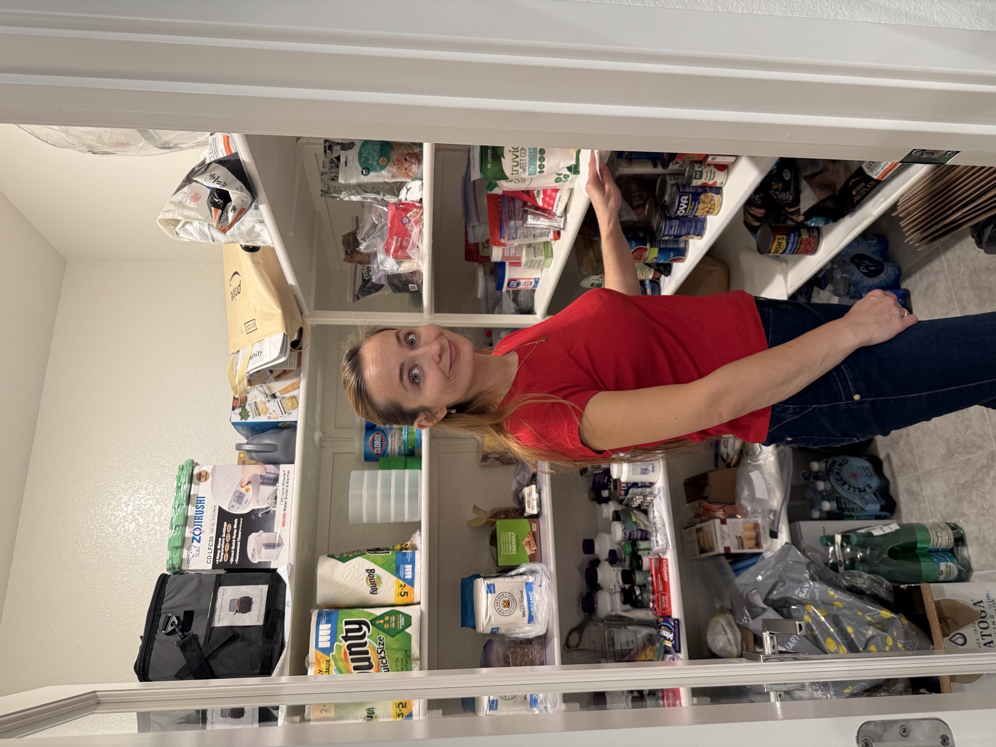 Crew member sorting labeled pantry shelves during a home organizing visit